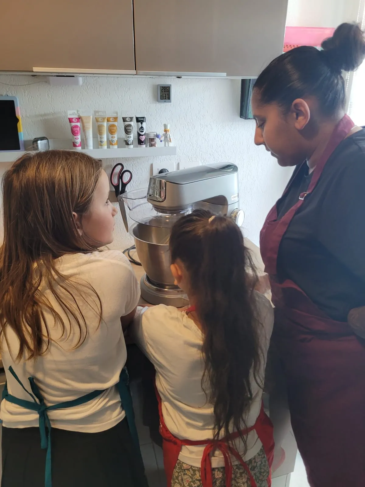 Sarah anime un atelier pâtisserie avec deux enfants autour d’un robot pâtissier