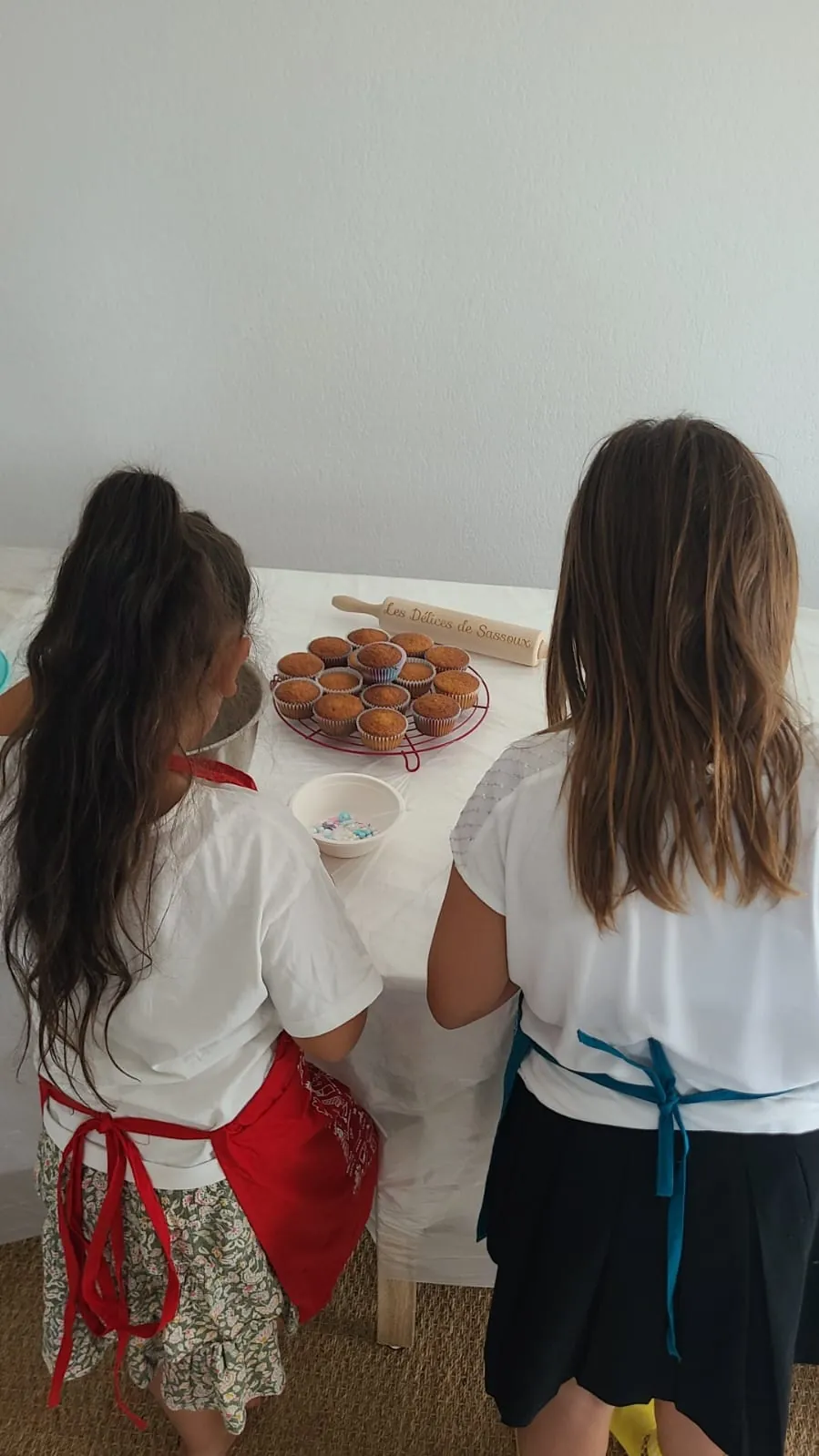 Deux enfants en tablier décorent des cupcakes avec un rouleau à pâtisserie personnalisé Les Délices de Sassoux