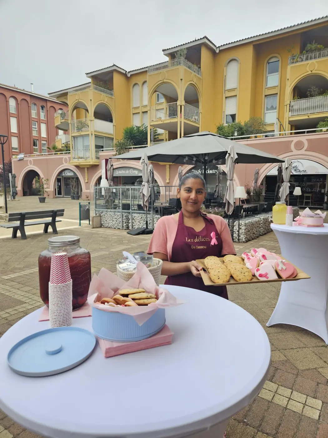 Sarah, des Délices de Sassoux, présente une planche de sablés et de biscuits cœur glacés lors d’un stand Octobre Rose à Port Ariane