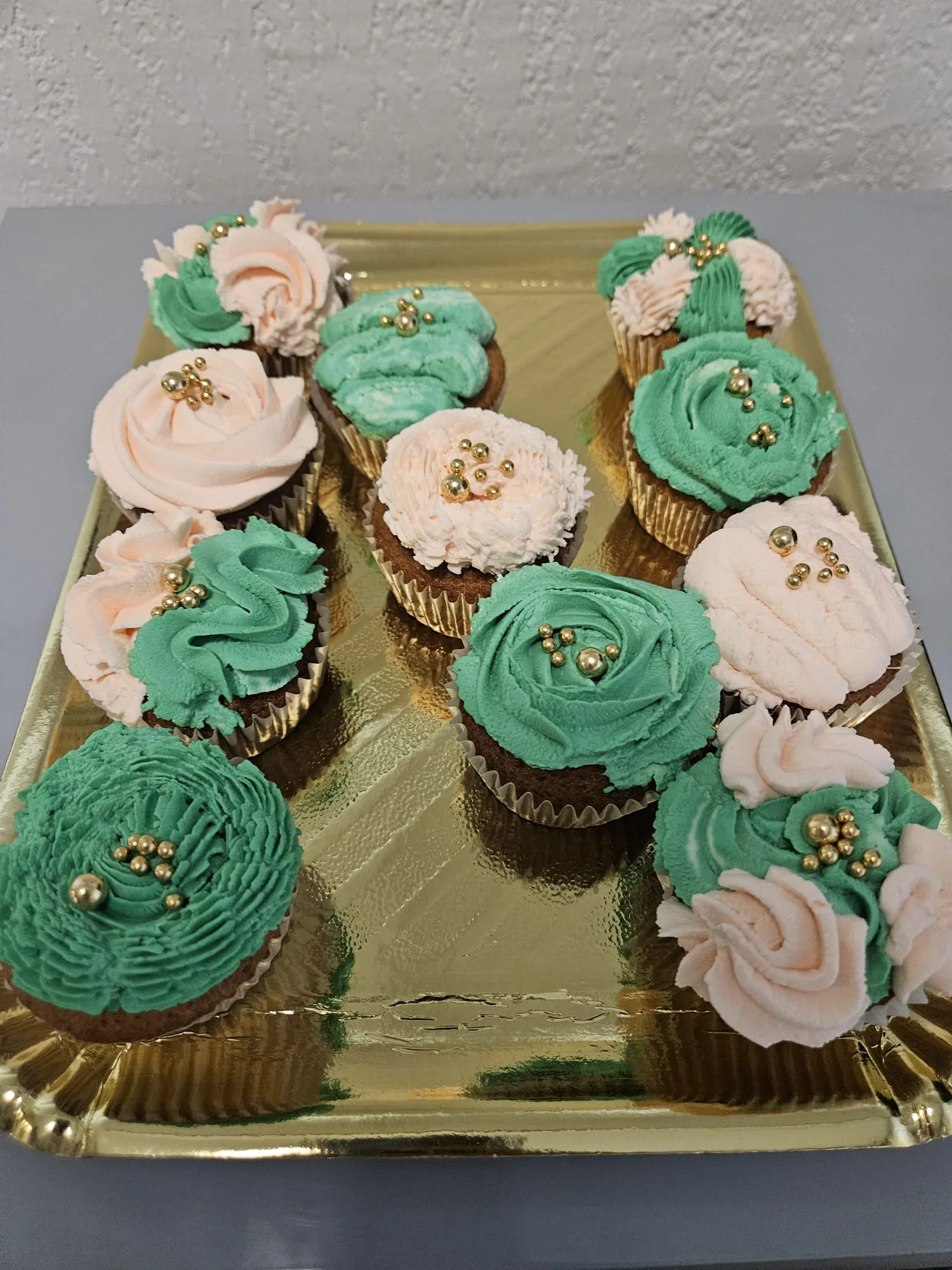 Cupcakes en spirale verte et blanche avec feuille d'or, sur plateau doré