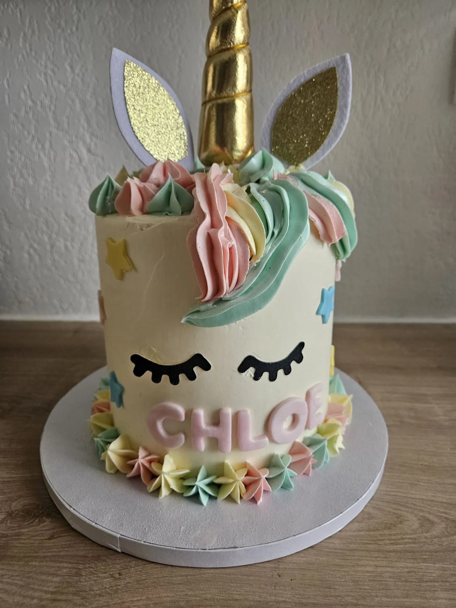 Layer cake blanc en forme de licorne, crinière pastel et corne dorée