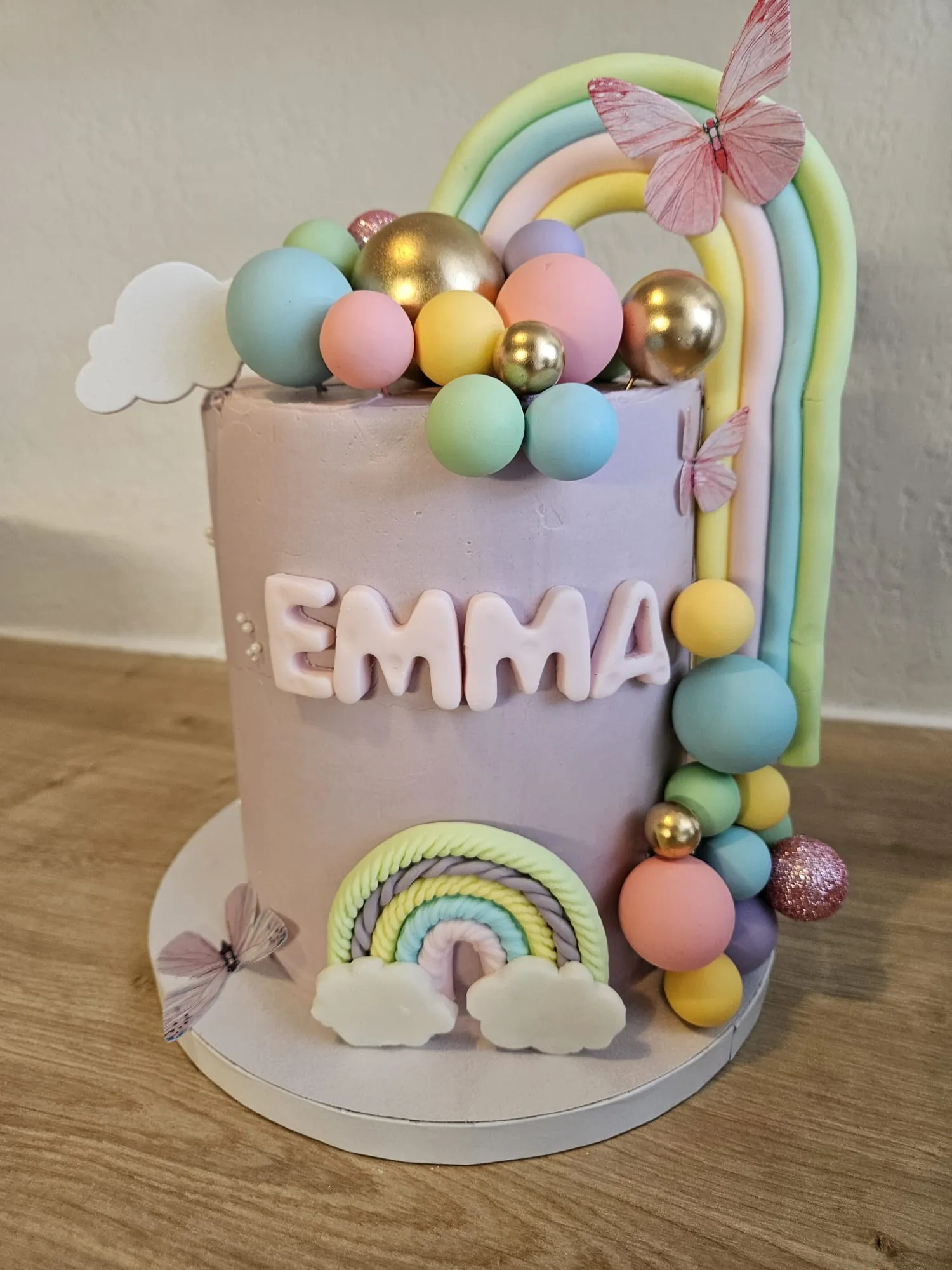 Layer cake mauve avec arc-en-ciel pastel et perles dorées