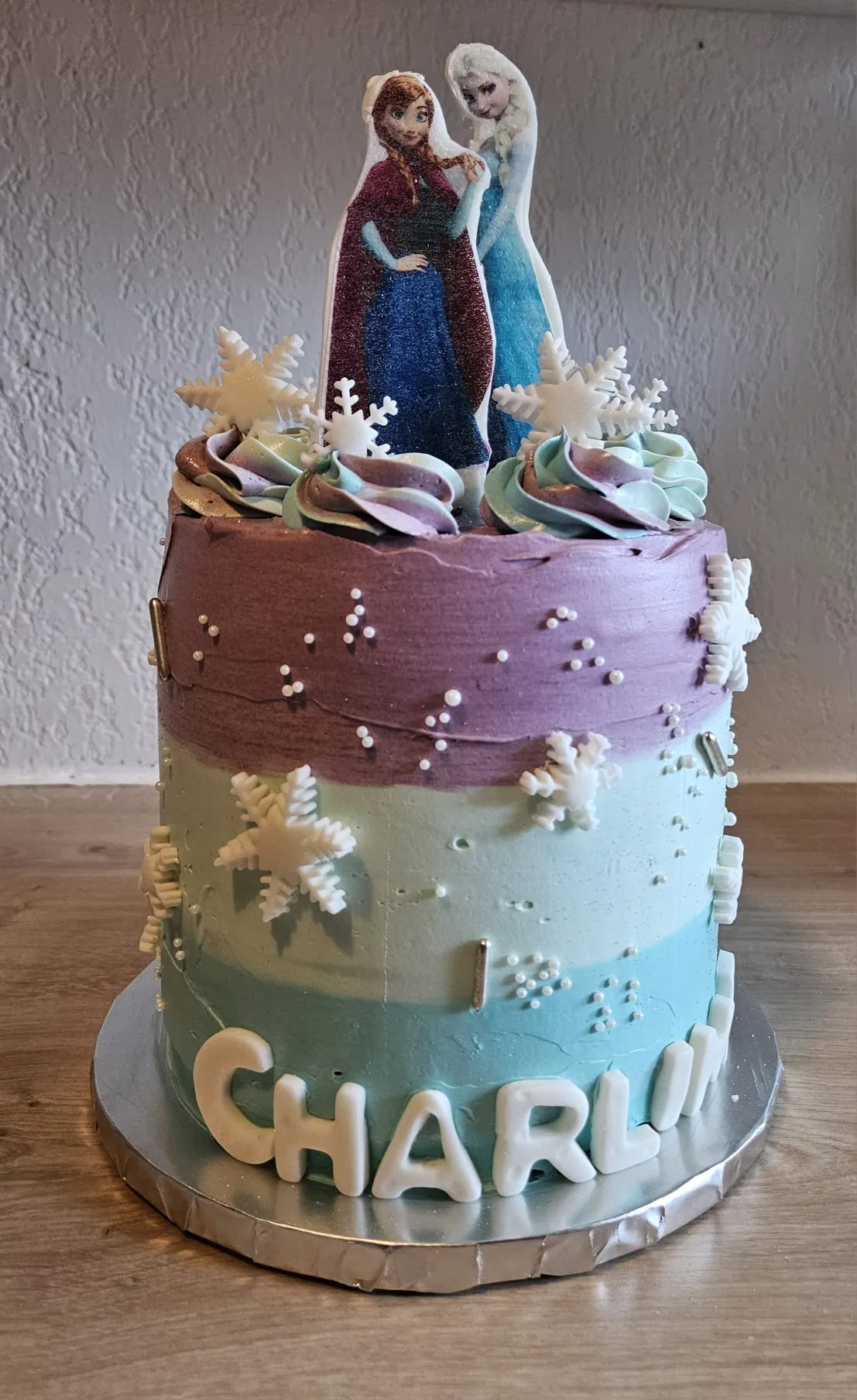 Layer cake dégradé bleu et violet avec fleurs et perles blanches en pâte à sucre