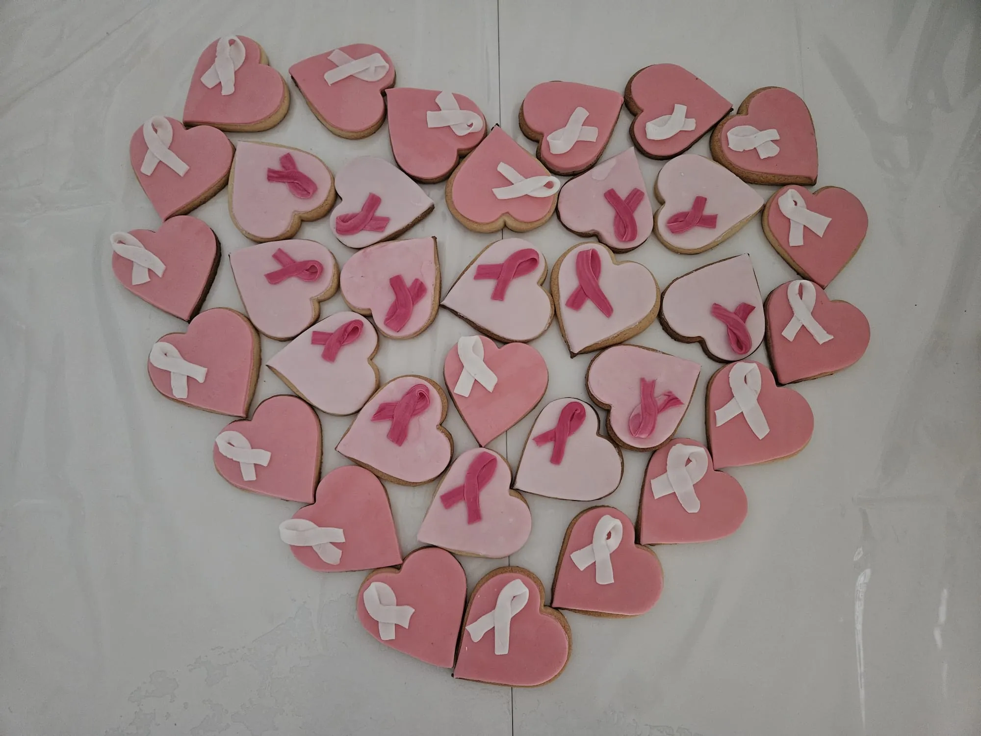 Sablés en forme de cœur disposés en cœur, ruban rose